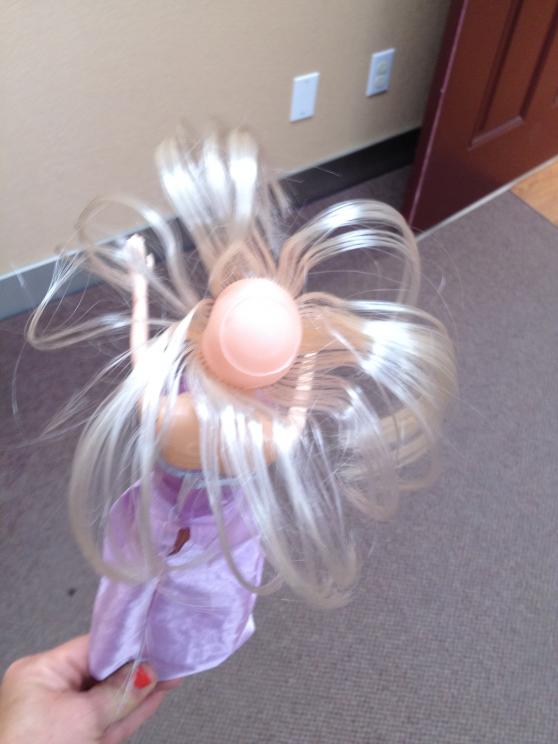 top view of barbie doll in purple dress with ponytail removed showing  lack of hair on the top of the doll's head